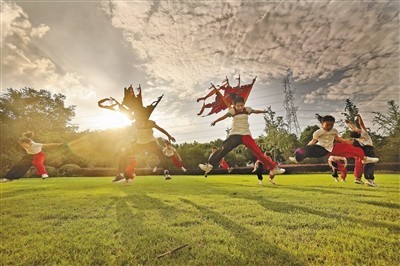 临近正式演出，同学们放学后在草地上练习大跳。　　徐培钦摄（影像中国）