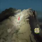 游客為舉國(guó)旗夜爬男子照亮上山路 眾人電筒助行