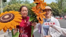 聾啞大媽穿旗袍捧向日葵為考生加油 無聲守護(hù)暖人心