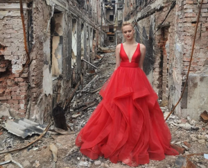 乌克兰女生穿红色礼服参加废墟里的毕业舞会