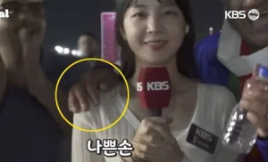 韩国女记者遭球迷强搂仍面带微笑 对方故意撞向她