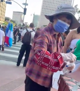 亞裔婦女在抗議現(xiàn)場撿礦泉水瓶