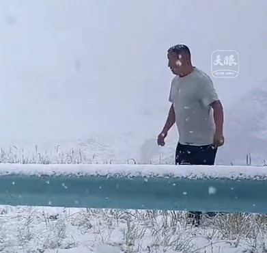新疆伊昭公路8月突然降雪，游客穿着短裤在雪中跺脚
