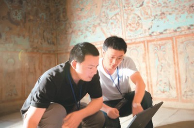 　2008年，黄先锋（左）与团队同事在敦煌莫高窟进行三维扫描，并进行相关数据处理。