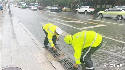 暴雨致路面积水 市民清理下水道口 警民同心保畅通