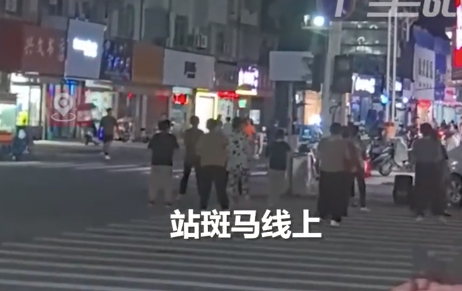 大媽在十字路口斑馬線上跳廣場舞 旁邊車來車往險象環(huán)生