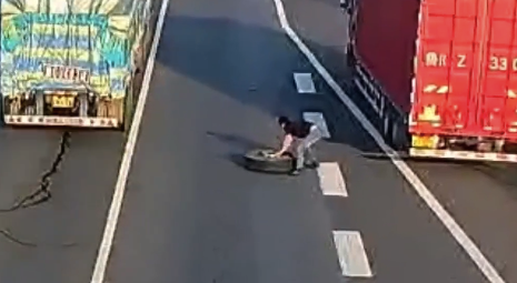 货车高速掉落备胎后车紧急避让 热心司机奋力挪轮胎