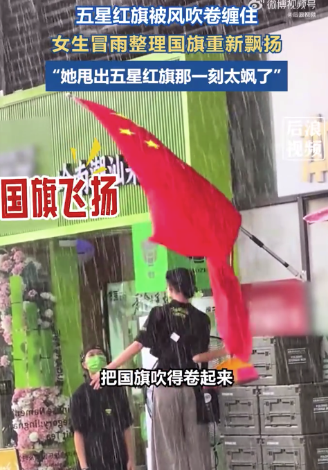 女生冒雨踩凳整理让国旗重新飘扬 网友：她甩出五星红旗那一刻太飒了