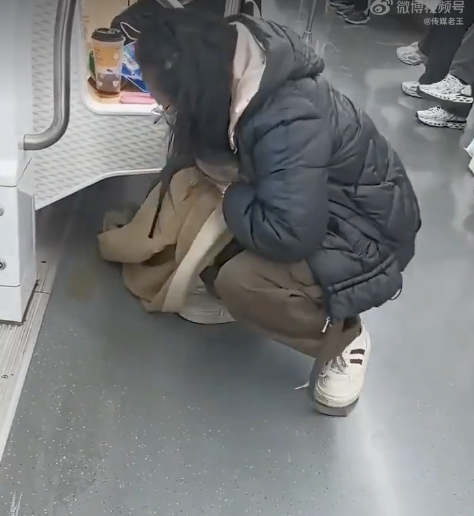 女子在地铁上用围巾擦拭污渍