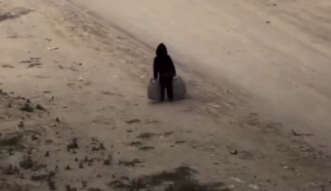 巴勒斯坦男孩吃力地提着两个大水桶 