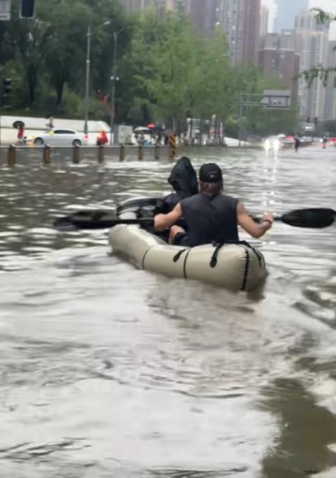 成都暴雨一男子划船出行 展现成都人的松弛感