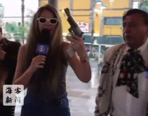 巴西女记者报道世界杯时突然被递枪 笑着接过枪还说“枪太重了”