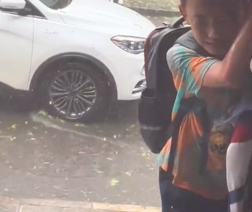 男孩窩在墻邊躲冰雹嚇得哇哇大哭 男子暖心幫忙