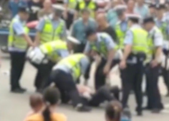 抱婴儿男子被按在地 派出所：他打交警五六拳，已带回警局