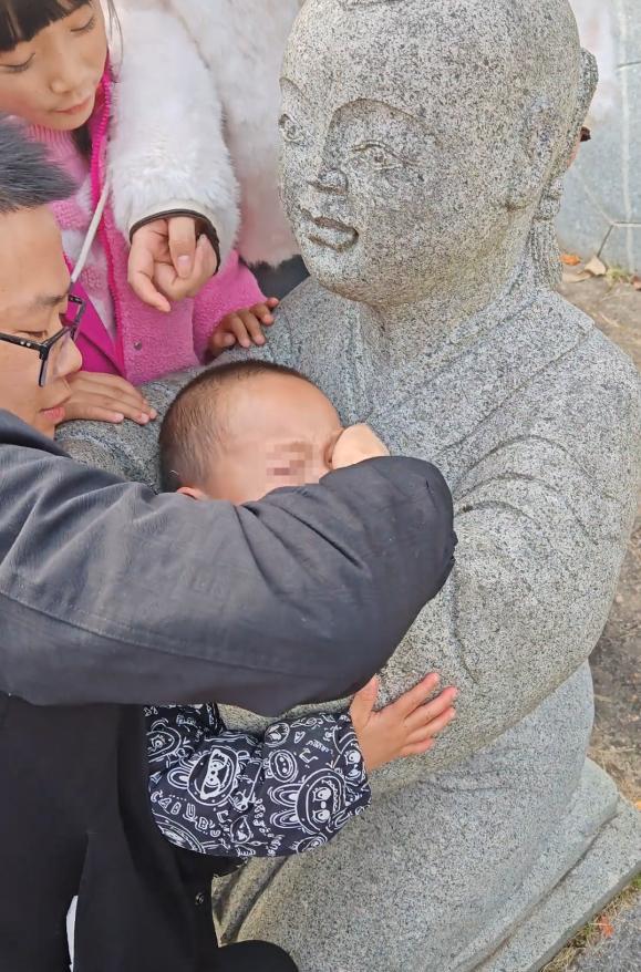 小孩一头扎进石像怀里出不来 家长回应:评论区笑不活了!
