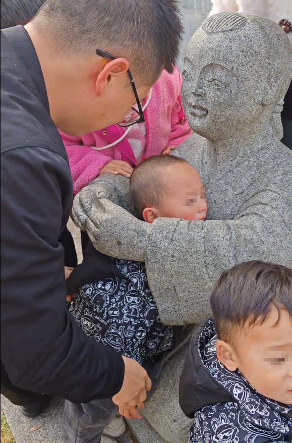 小孩一头扎进石像怀里出不来 家长回应:评论区笑不活了!