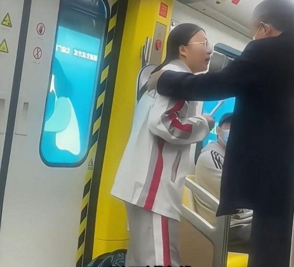 地鐵上女孩倚門苦讀 男子起身讓座