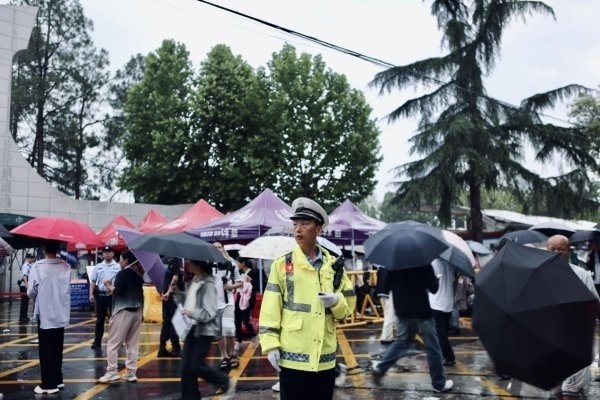 暴雨中光脚执勤的交警祝福考生 风雨中的“警”色