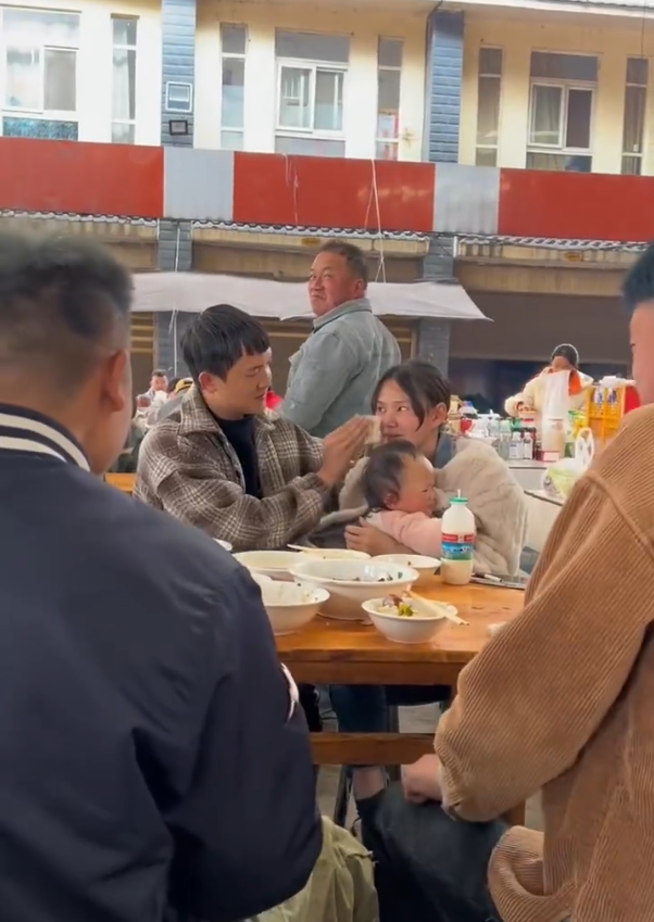 丈夫给抱孩子妻子喂饭