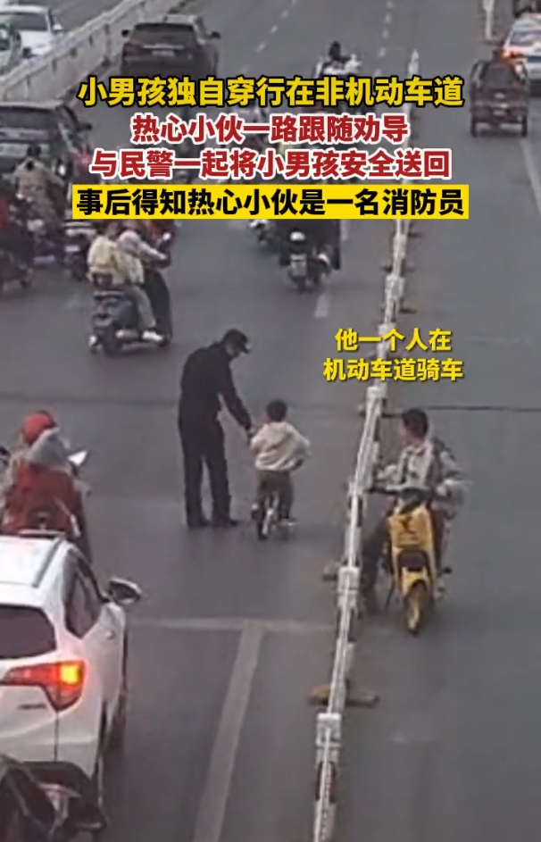 男孩机动车道骑单车 小伙跟随劝导