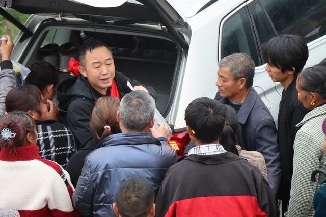 村民冒雨含泪送驻村书记 村民们有的提着东西、有的拿着锦旗