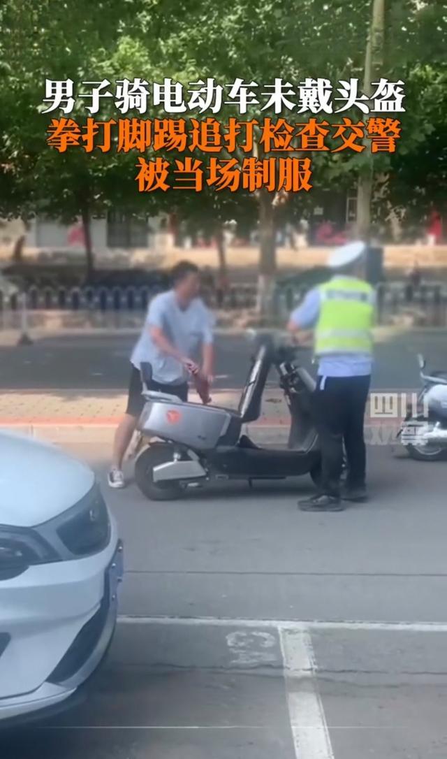 男子未戴头盔被拦打交警 下意识地伸手拉了一下男子 男子竟然一拳打在了交警的脸上