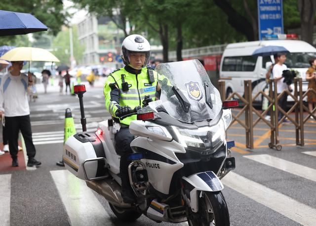 考点积水民警冒雨为考生铺路 风雨无阻保高考畅通