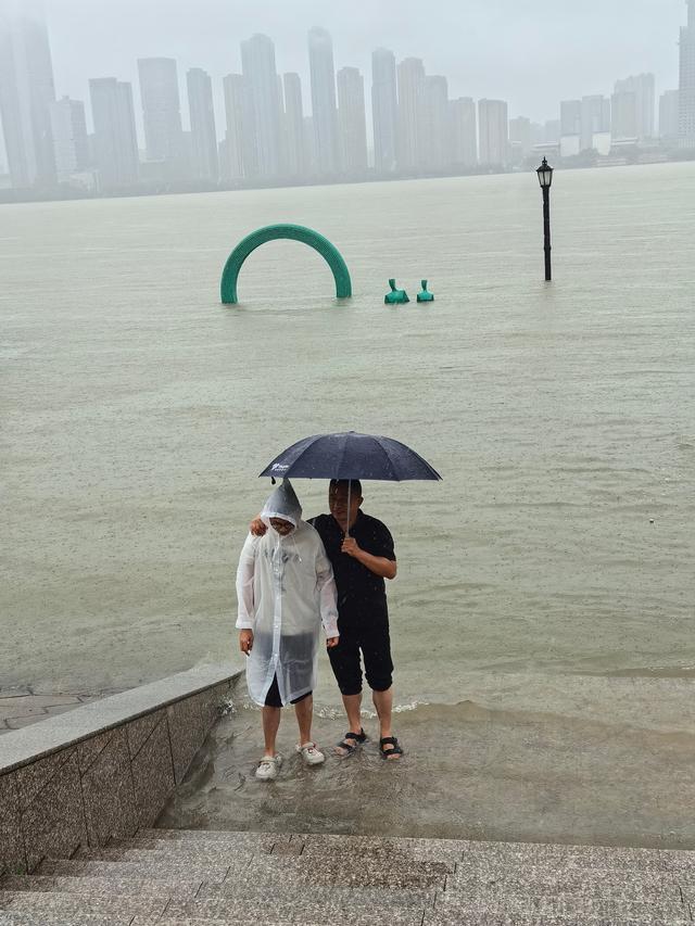 武汉江滩“一家五口”雕塑“三孩”被淹没，救援队巡逻劝阻游客下水