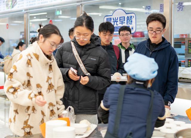 中学领导食堂门口给学生发免费早餐