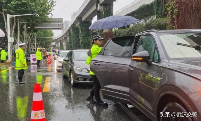 交警在大雨中为高考生撑伞 风雨无阻护考路