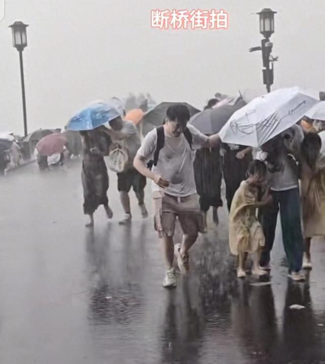 游客西湖边突遭暴雨蹲地列阵