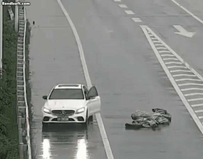 司機暴雨中挪80斤攔路雨布獲見義勇為獎 女子冒雨迅速排險