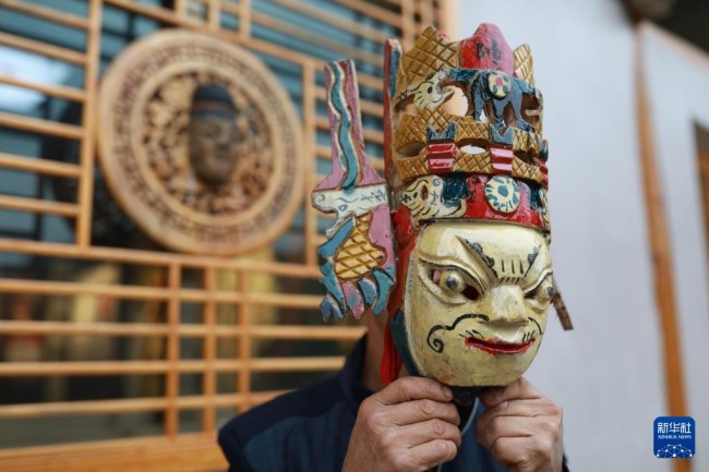 10月17日，在岑巩县平庄镇平庄村，肖光华在表演前佩戴面具。