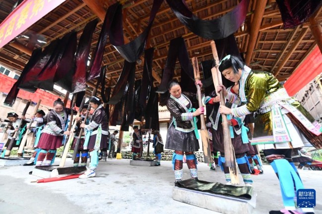10月19日，在桂黔乌英苗寨亮布文化节上，苗族妇女向观众展示捶打亮布。<br><br>