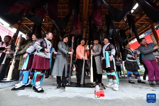 10月19日，在桂黔乌英苗寨亮布文化节上，柳州女企业家和苗族妇女一起体验捶打亮布。