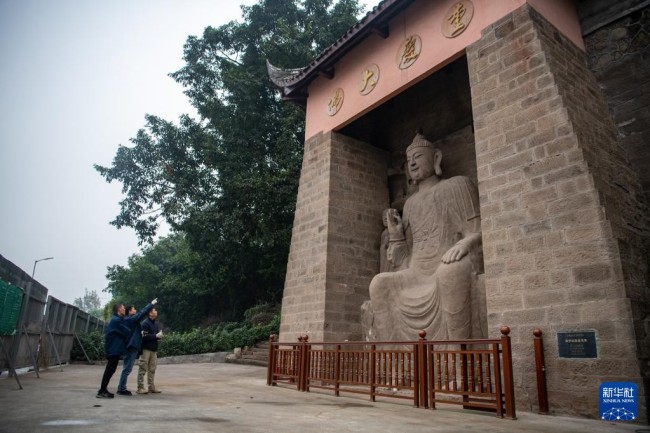 　　11月12日，中国文化遗产研究院修缮团队在弹子石摩崖造像前讨论修缮方案。新华社记者 唐奕 摄