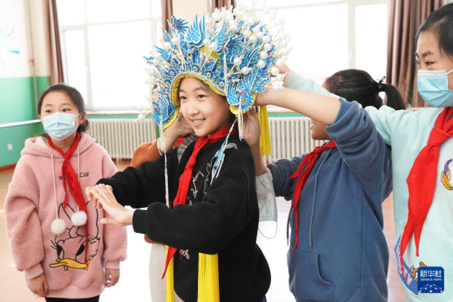 11月24日，石家庄鹿泉区第二实验小学戏剧兴趣班的学生体验戴盔头。新华社发（许建园 摄）