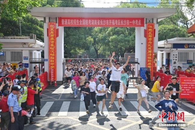 2023年6月9日，湖南省2023年高考结束，考生冲出长沙市一中考点。中新社记者 杨华峰 摄