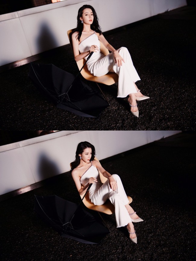 热巴穿斜肩连体裤撑黑伞 眼神霸气酷飒十足