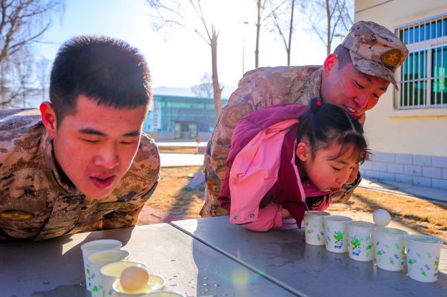 一同比拼《吹球过河》趣味游戏