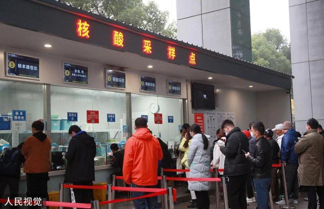 2022年12月10日，南京，市民在鼓楼医院的核酸检测点排队参加核酸检测。 人民视觉 图