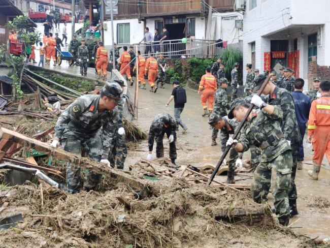 6月20日，武警官兵正在清理受灾房屋。 侯鲁晋 摄