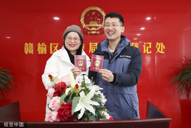 2022年2月22日，一对新人在江苏省连云港市赣榆区婚姻登记处展示刚领取的结婚证。