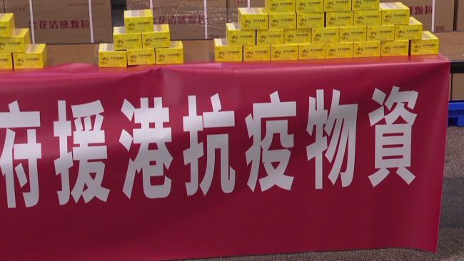 2022年2月20日，首批抗疫中成药物资‘金花清感颗粒’抵达香港。“香港各界感谢中央政府援港抗疫物资”横幅。（视频截图）
