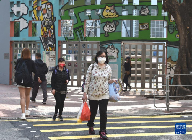 　3月5日，在香港湾仔，市民佩戴口罩出行。