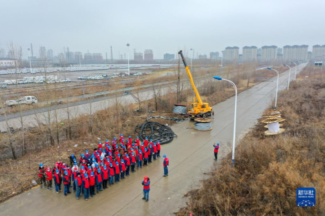 3月13日，国网吉林供电公司工作人员在隔离方舱施工现场集结，准备铺设电缆。