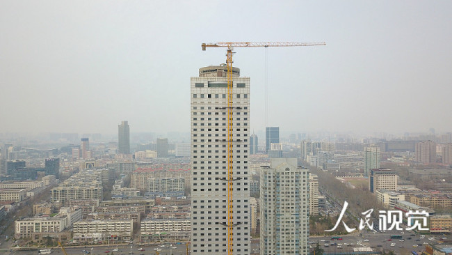 济南：挖掘机爬157米高拆楼