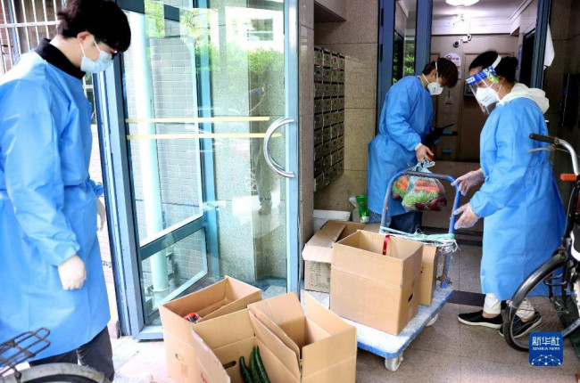4月11日，社区志愿者在分拣为居民配送的生活物资。
