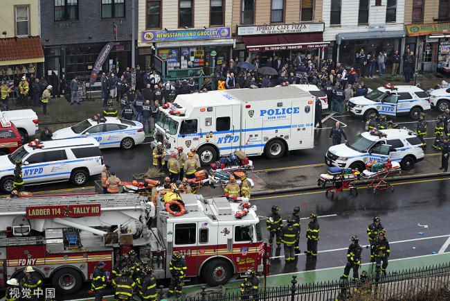当地时间2022年4月12日，美国纽约，警方和紧急救援人员在事发现场日落公园附近的第36街地铁站附近勘查。