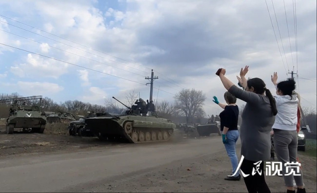 俄罗斯军备穿过乌克兰哈尔科夫地区，民众路边挥手。